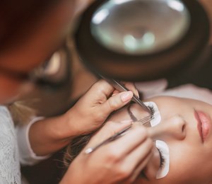 Woman receiving eyelash extensions
